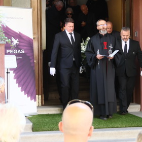 Rakev byla vynesena ven v čele s knězem.