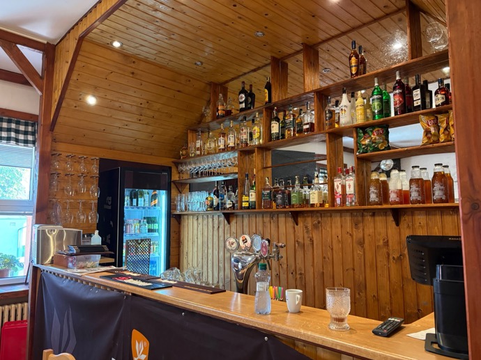 FOTO: Pohled na bar hospůdky, který je kompletně zasazen do dřevěného obložení. – stránka 49
