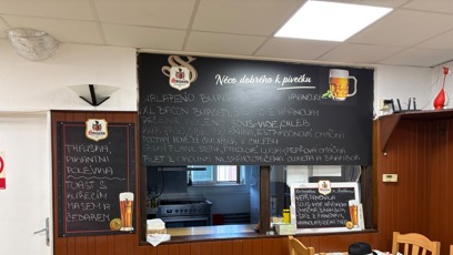 FOTO: Detail vyvěšené tabule s nabídkou specialit a menu pro návštěvníky.