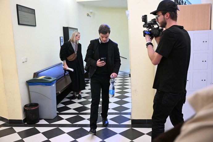 FOTO: Adam Kraus přichází k soudu začtený do mobilu. – stránka 8