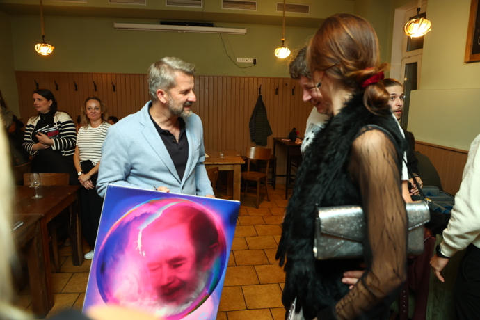 FOTO: Spisovatel Rudolf Merkner obdržel během slavnostního křtu originální obraz, který ho viditelně potěšil. – stránka 7